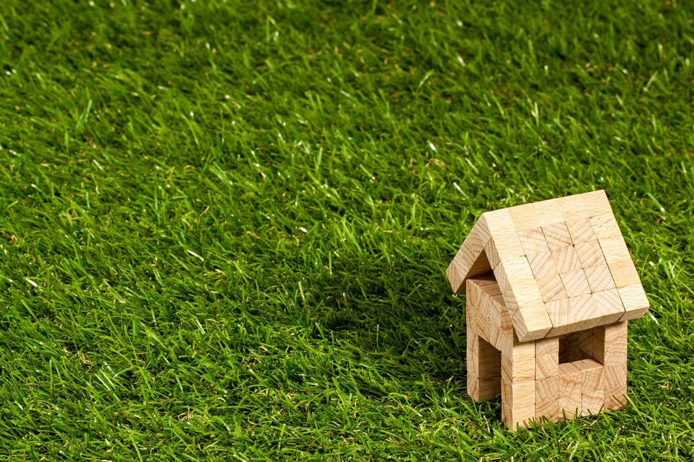 Miniature wooden house on artificial turf 