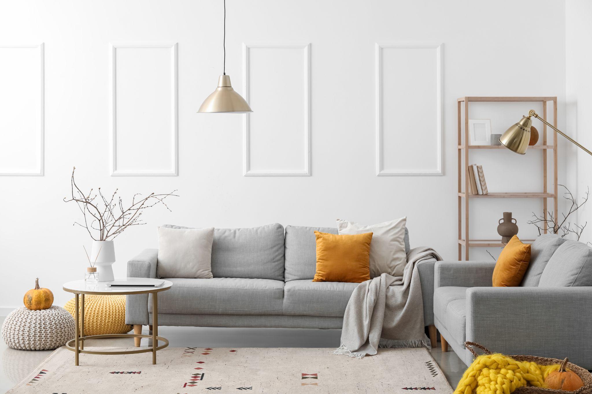 Interior of light living room with grey sofas and shelving unit