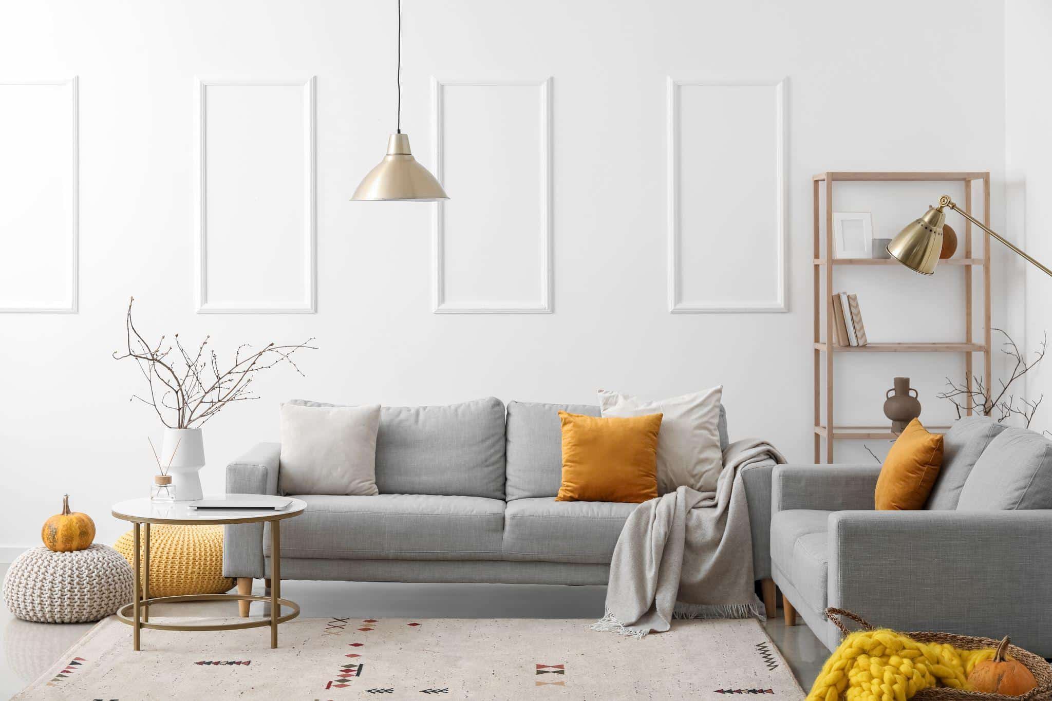 Interior of light living room with grey sofas and shelving unit