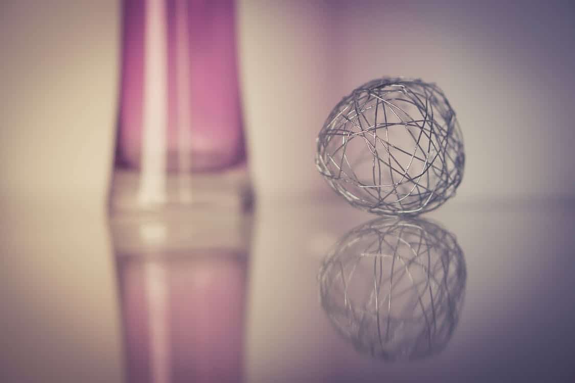 Free Abstract wire ball with soft purple tones and reflection on a smooth surface, creating a contemporary art feel. Stock Photo