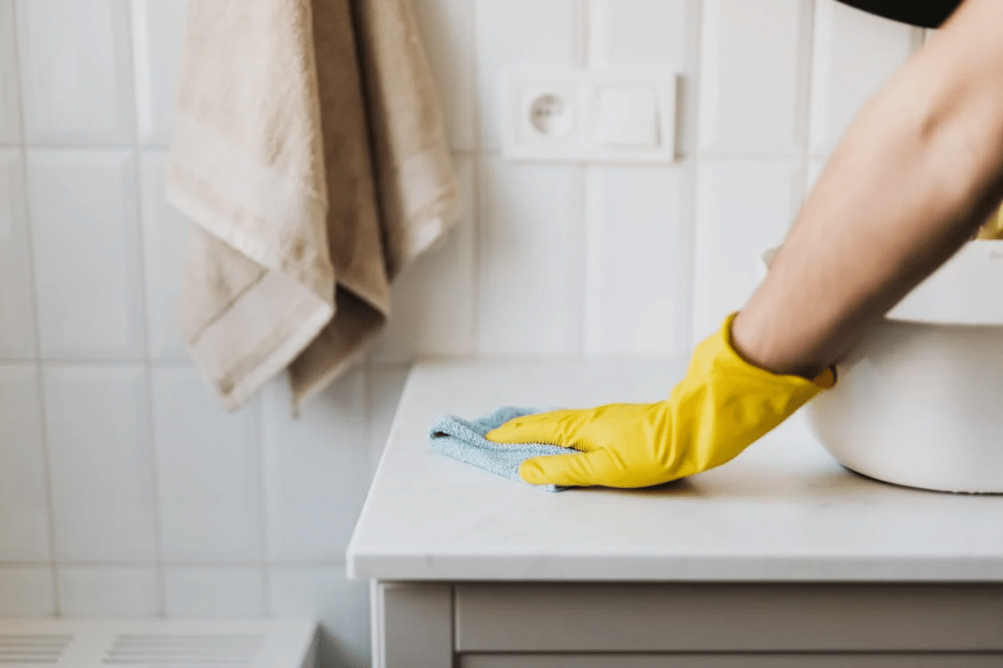 Professional cleaner tackling overlooked areas to meet inspection standards during house cleaning